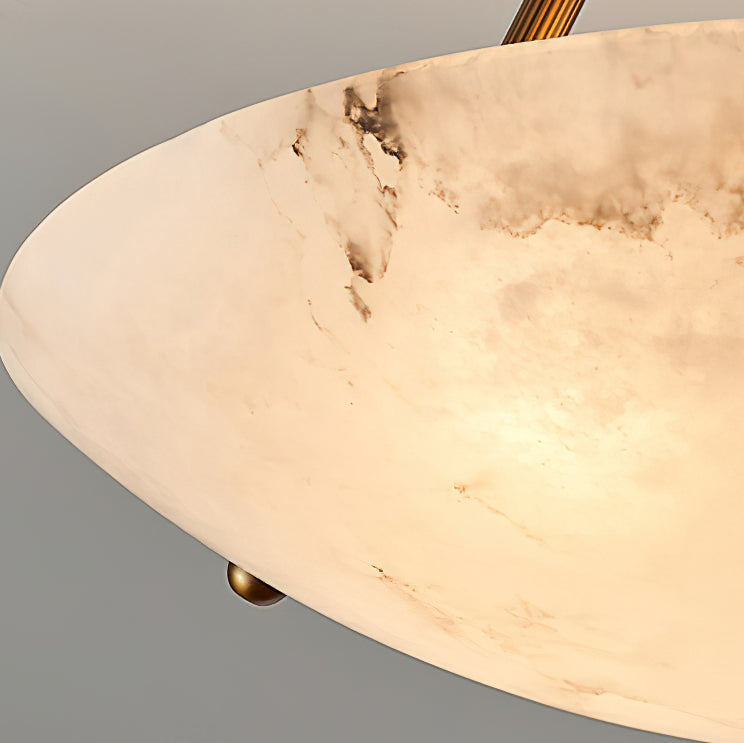 Close view of the dark veining running through the alabaster bowl of this Clérachic ceiling light, with a brass stud at the base.