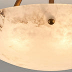 Detail of the stone's cloud-like grey veining and the brass stud on the rim of this Clérachic alabaster bowl light.