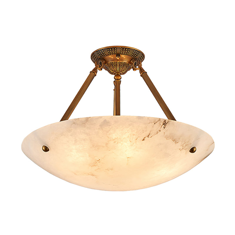 This Clérachic alabaster ceiling light shown lit on white, its wide bowl showing soft, cloudy veining.