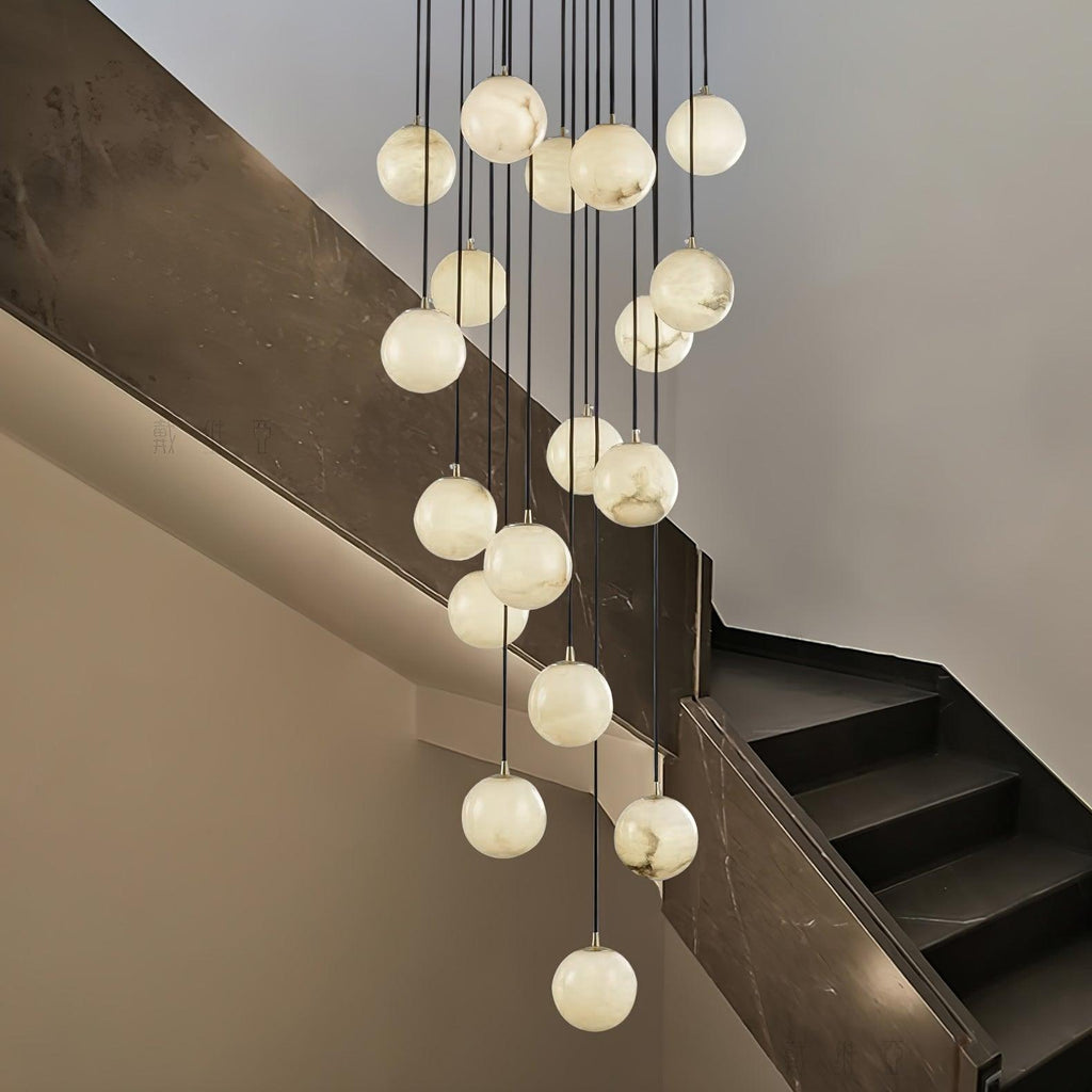 Clérachic alabaster spheres drop at different heights past a dark marble stair wall, each glowing a soft white.