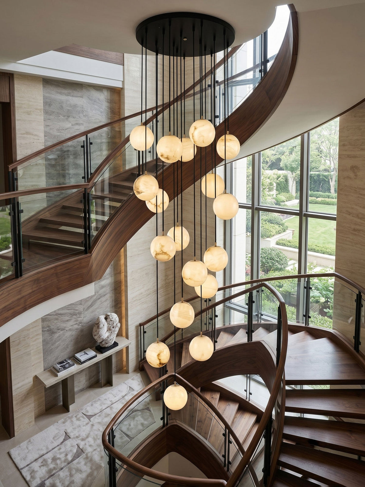 This Clérachic cluster of glowing alabaster spheres hangs from a black canopy down a curved walnut staircase beside a tall garden window.