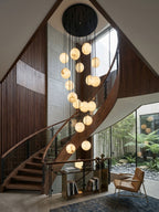 Alabaster spheres from Clérachic spiral down a double-height stairwell with slatted walnut panelling and a glass wall to a courtyard.