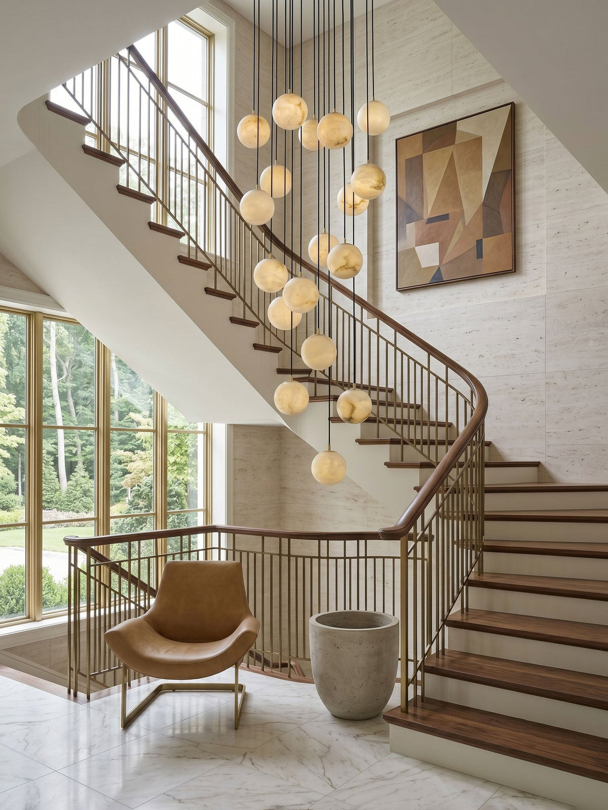 A Clérachic sphere cluster lit above a curved staircase with a brass and wood rail, a tan armchair and a large geometric painting.