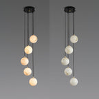 Two five-sphere Clérachic pendants side by side on grey, one with warm-toned alabaster spheres and one with paler spheres.