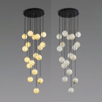 Two larger Clérachic clusters from a round black canopy on grey, one in warm lit alabaster and one in a paler white.