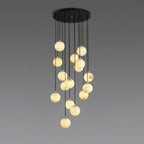 Clérachic cluster of lit alabaster spheres on black cords from a round canopy, shown against a grey gradient backdrop.