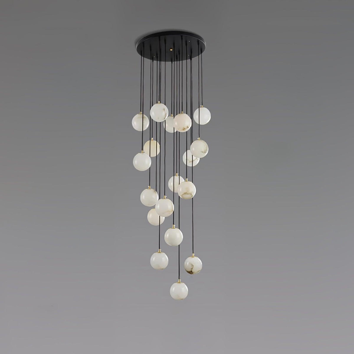 Clérachic cluster of pale, white-toned alabaster spheres hanging from a round black canopy, on a grey backdrop.