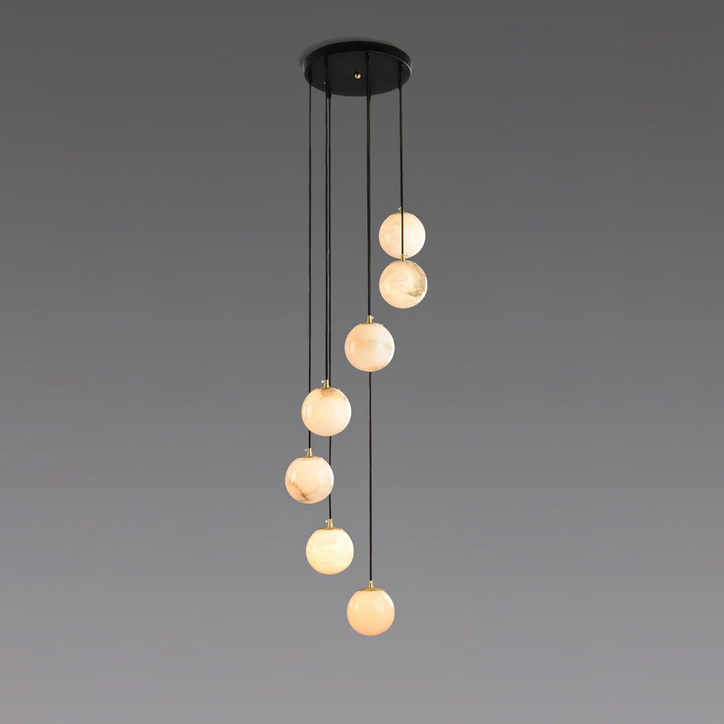 Six warm alabaster spheres from Clérachic hang from a round black canopy on a grey backdrop.