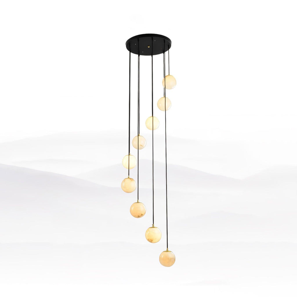 Slim run of Clérachic alabaster spheres in a tall spiral on long black cords, against a pale mist-landscape backdrop.