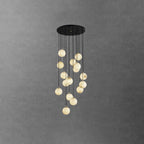 Dense Clérachic alabaster sphere cluster, lit pale cream, hanging from a wide round black canopy on a dark grey wall.