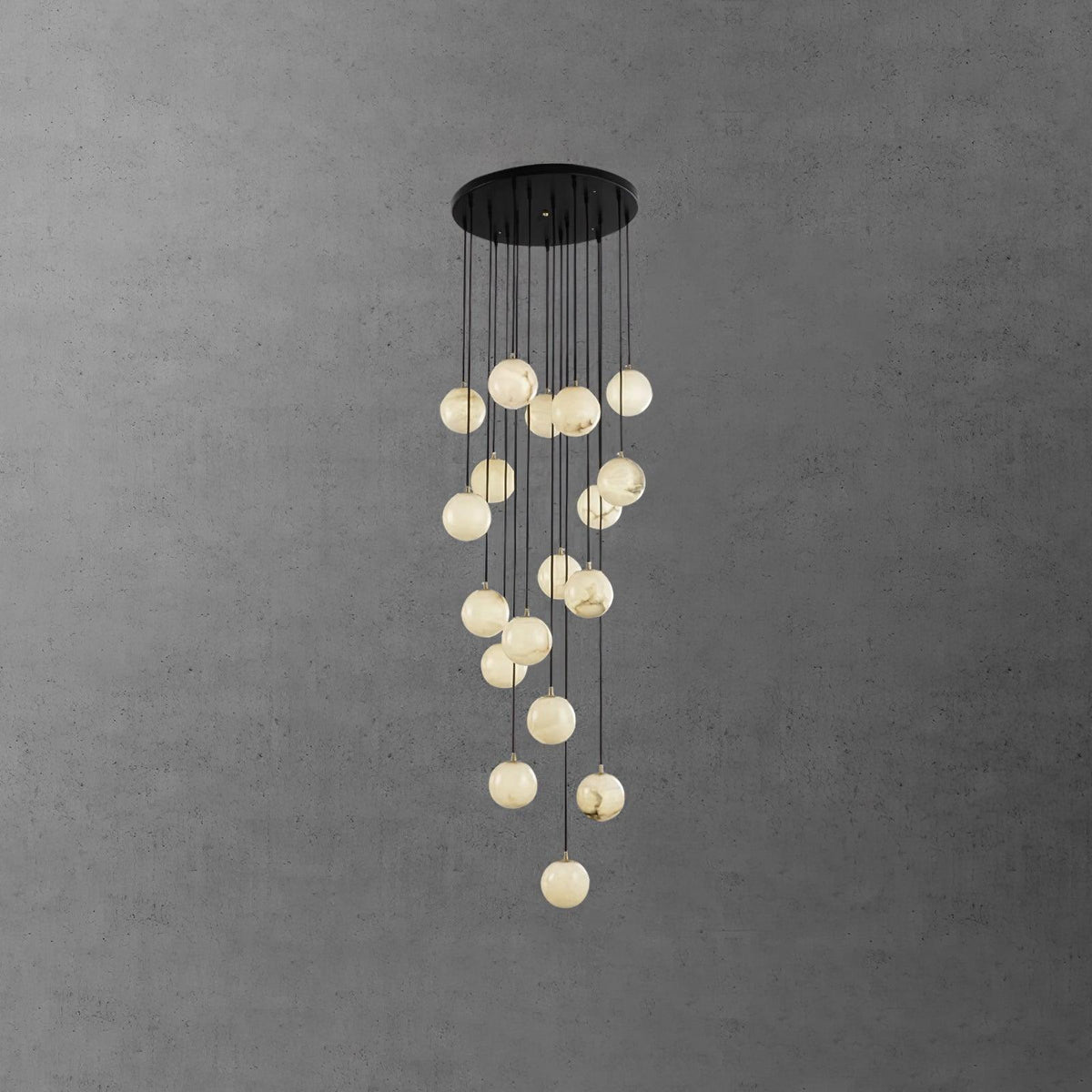 Clérachic alabaster sphere cluster hanging long beneath a round black canopy against a textured dark grey wall.