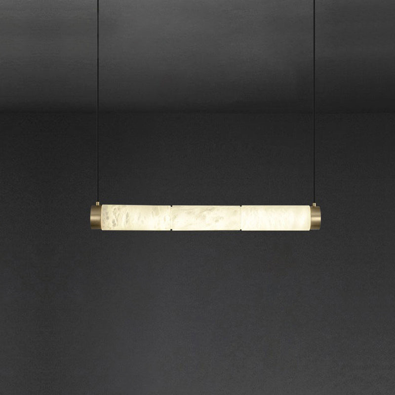 Clérachic alabaster bar pendant turned horizontal, glowing stone segments held between two brushed brass end caps.