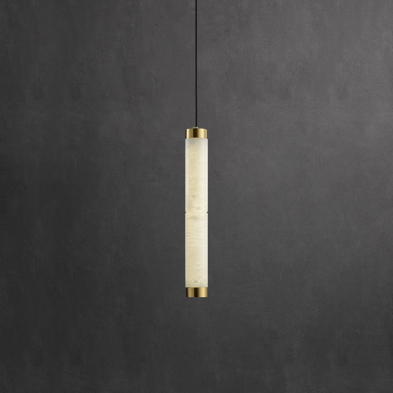 Clérachic pendant lit from within, the stone's cloudy veining reading warm cream against a charcoal wall.