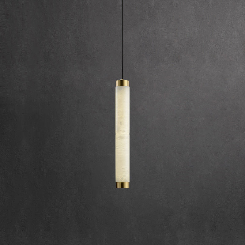 The Clérachic round pendant hung low, its slim alabaster column bracketed at each end in warm brushed brass.