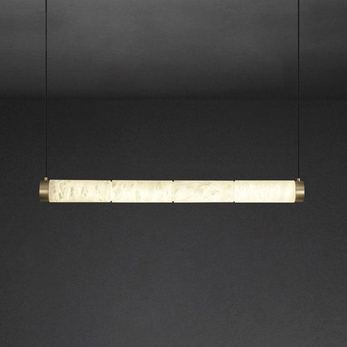 The Clérachic strip pendant at its longest, a wide ribbon of backlit stone closed with brushed brass caps.