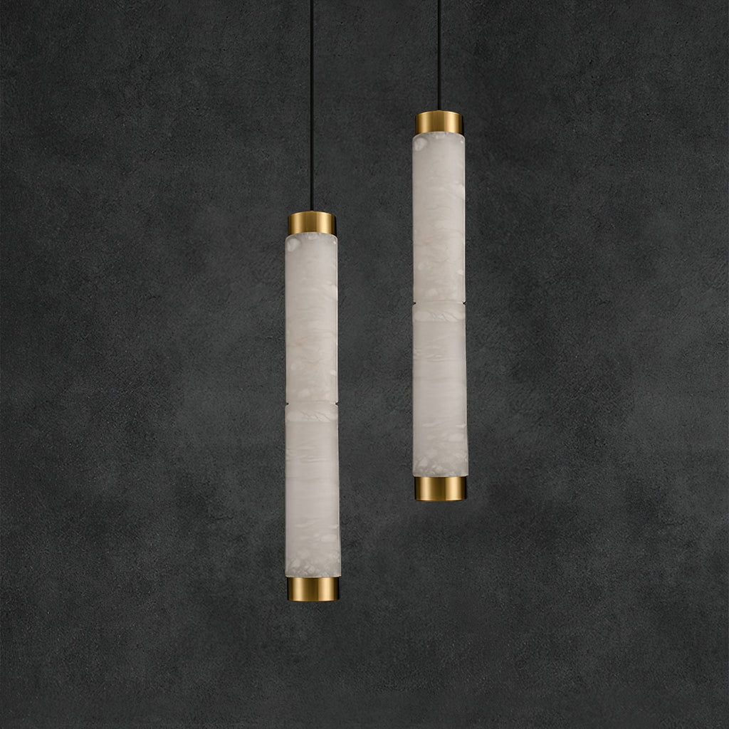 The Clérachic pendants staggered at two drops, brass caps catching light against a charcoal plaster wall.