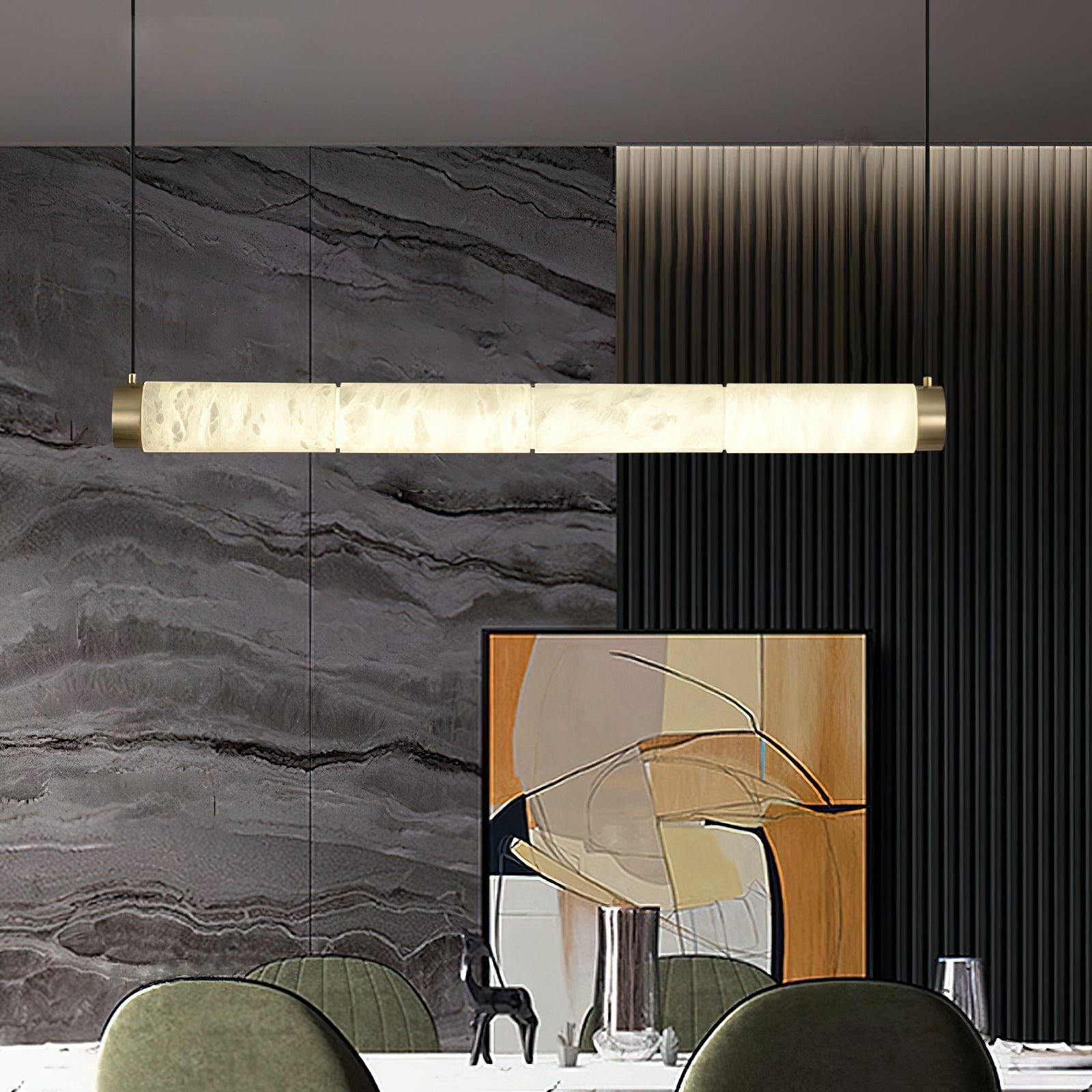 The Clérachic strip pendant in a dining room, its lit stone bar set against grey marble and black fluted panelling.