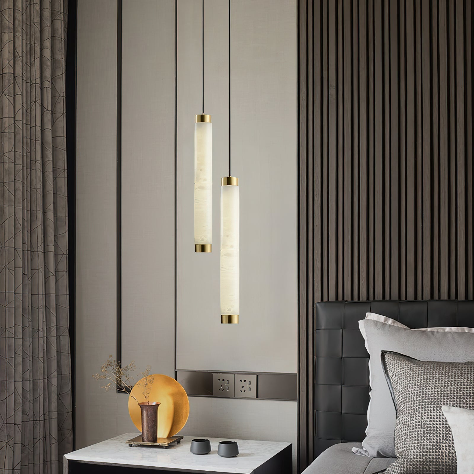 The Clérachic pendants dropped at two lengths beside a bed, glowing against dark fluted wood panelling.