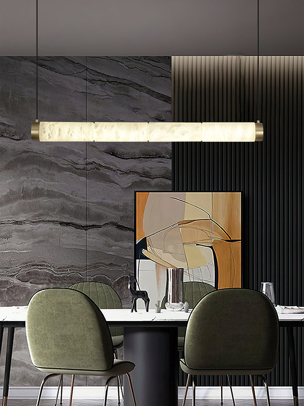 Clérachic strip pendant spanning a dining table, a long bar of lit alabaster against a veined grey stone wall.