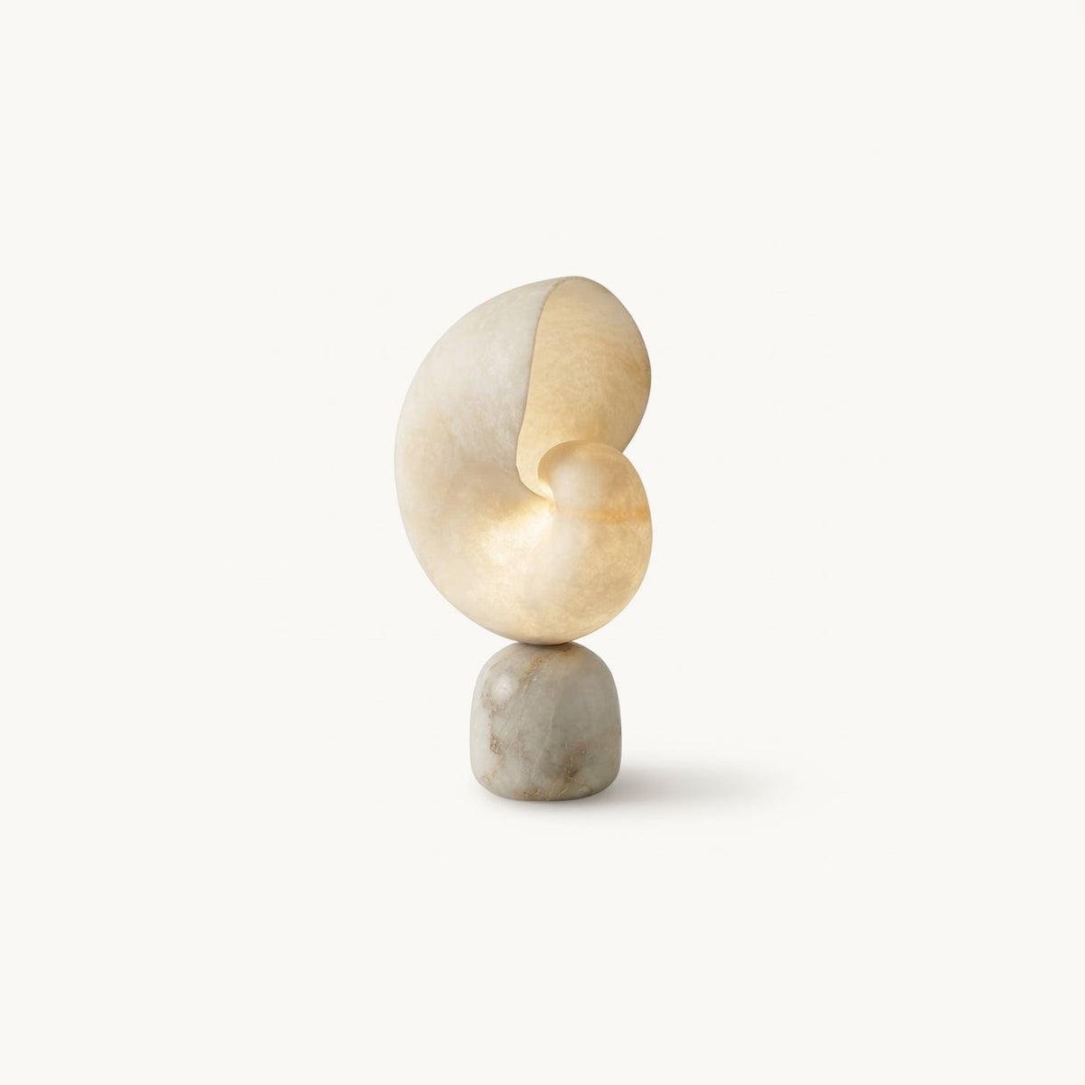 Clérachic alabaster table lamp with a spiral conch-shaped shade resting on a rounded stone base, shown on a plain white backdrop.