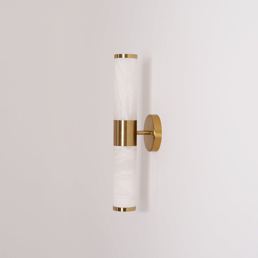 Side view of the unlit Clérachic wall light, with soft grey veining in the white tubes and thin gold rims at each end.