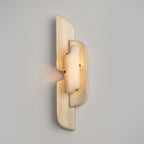 A Clérachic wall lamp with a warm glow through its alabaster panel, and light spilling sideways from the gap between the layers.