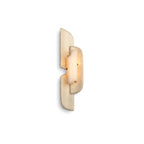 A Clérachic wall lamp lit on a white backdrop, shown as the mirror-image version with the panels turned the other way.