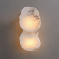 Clérachic two-light wall lamp with irregular alabaster marble panels glowing warm against a grey wall.