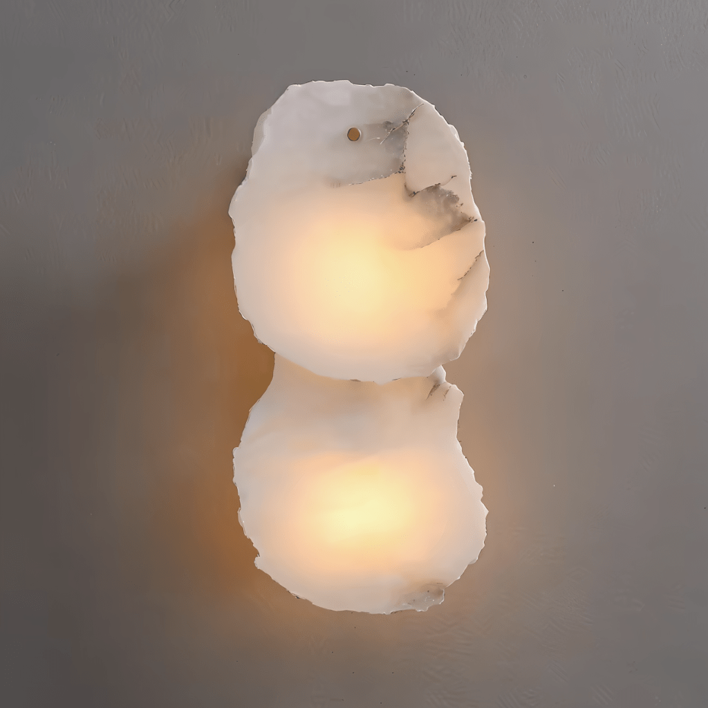Clérachic two-light wall lamp with irregular alabaster marble panels glowing warm against a grey wall.