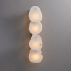 Clérachic four-light wall lamp with a vertical stack of raw-edged alabaster panels glowing softly on grey.