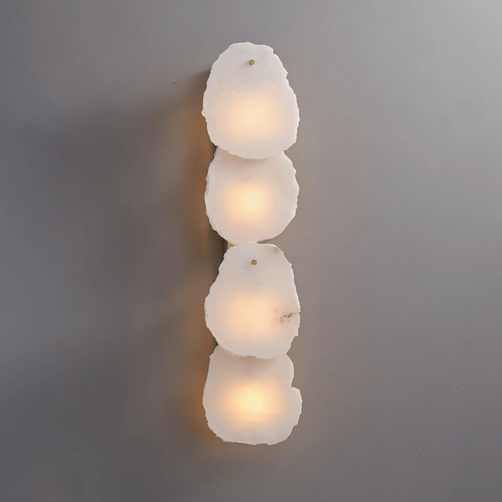 Clérachic four-light wall lamp with a vertical stack of raw-edged alabaster panels glowing softly on grey.