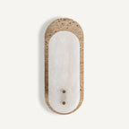 Front view of this Clérachic wall light, a white alabaster oval framed by a beige travertine plate, with two small brass-coloured screws.