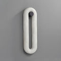 Clérachic Alabaster Wall Sconce seen straight on and switched off, the stone loop and its dark round wall fixing.
