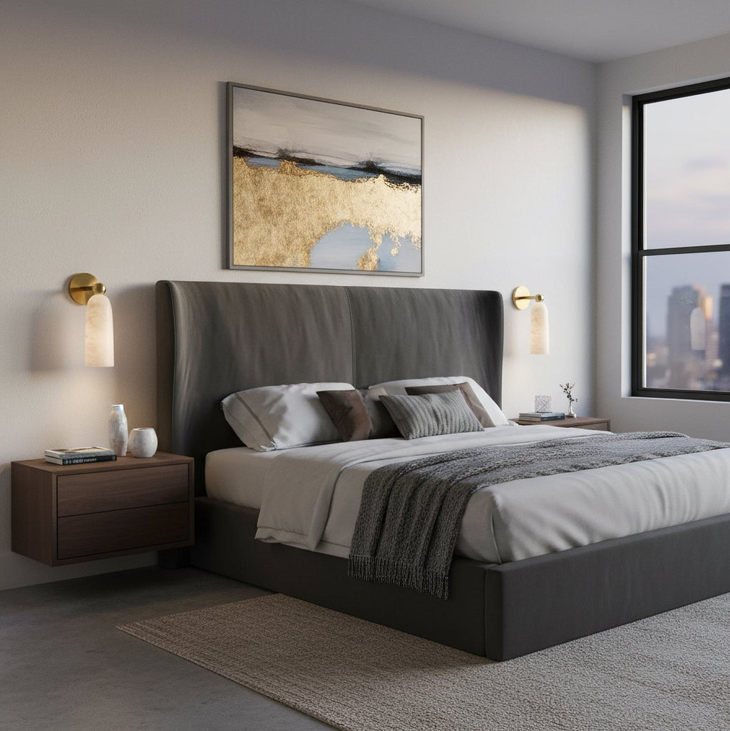 A pair of Clérachic alabaster wall lights beside a dark upholstered bed, with a city skyline visible through the window.