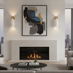 Clérachic alabaster sconces on either side of a framed abstract print above a linear fireplace, casting light up and down the wall.