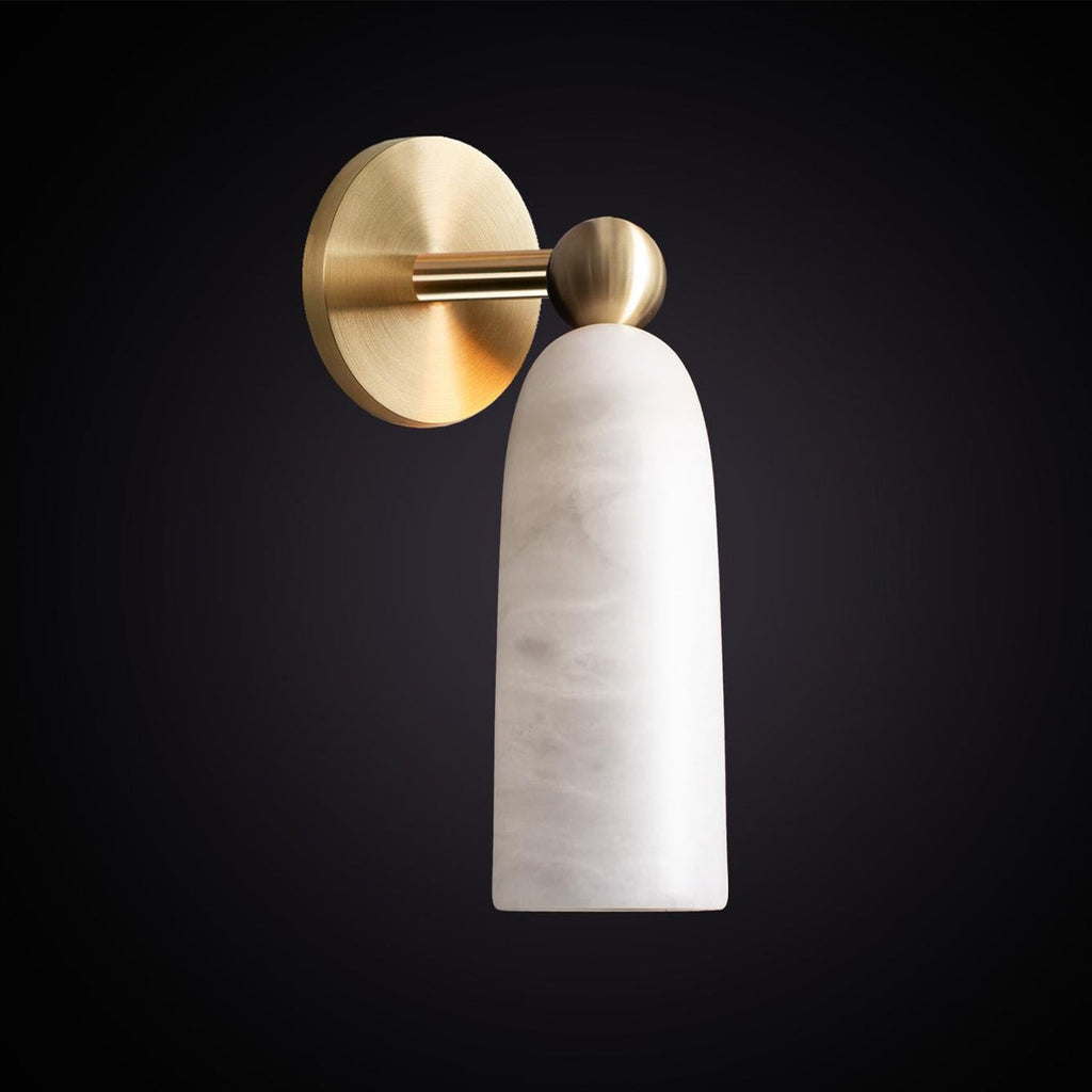 Close view of the veined white alabaster shade and brushed brass backplate of this Clérachic wall light against a near-black backdrop.