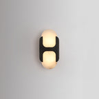 Clérachic Alabaster Wall Sconce with the black bracket, its warm inner glow reading as two rounded panes on a soft grey wall.