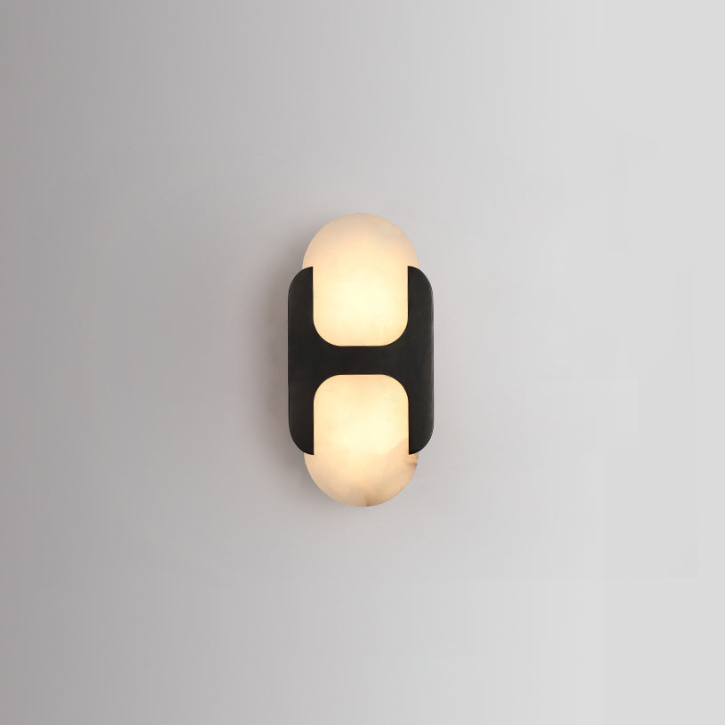Clérachic Alabaster Wall Sconce with the black bracket, its warm inner glow reading as two rounded panes on a soft grey wall.