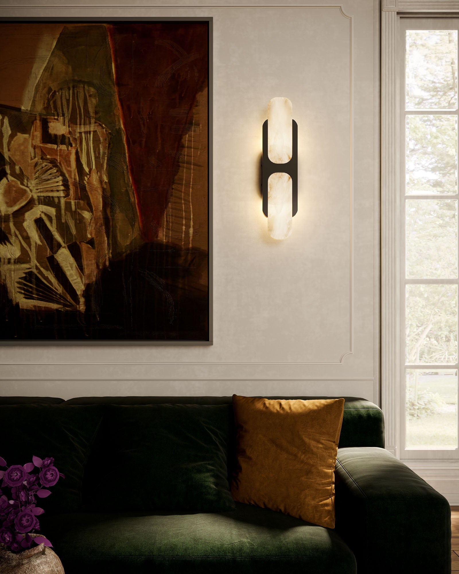 Clérachic Alabaster Wall Sconce in black lighting a panelled living-room wall above a deep green velvet sofa and framed artwork.