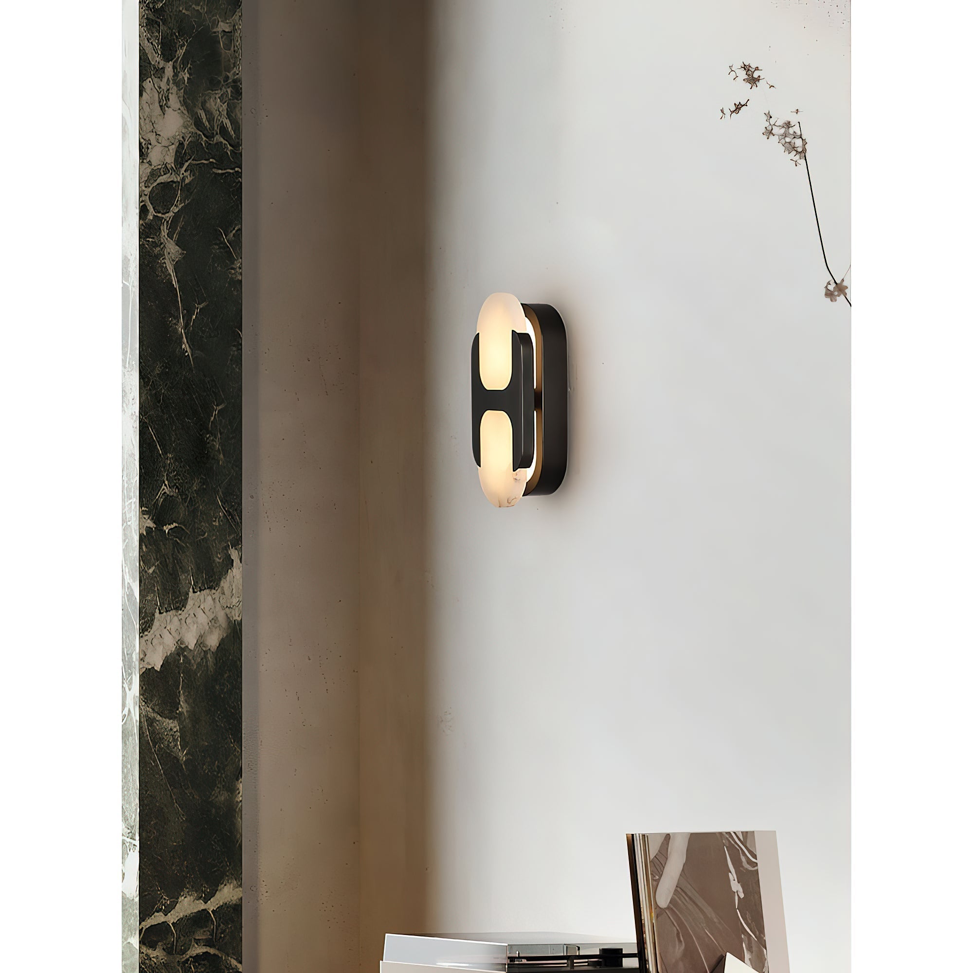 Angled view of the Clérachic Alabaster Wall Sconce in black, sitting close to the wall beside a dark green marble column.