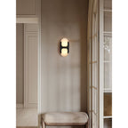 Clérachic Alabaster Wall Sconce in black on a taupe hallway wall, throwing soft light over an upholstered entry bench.