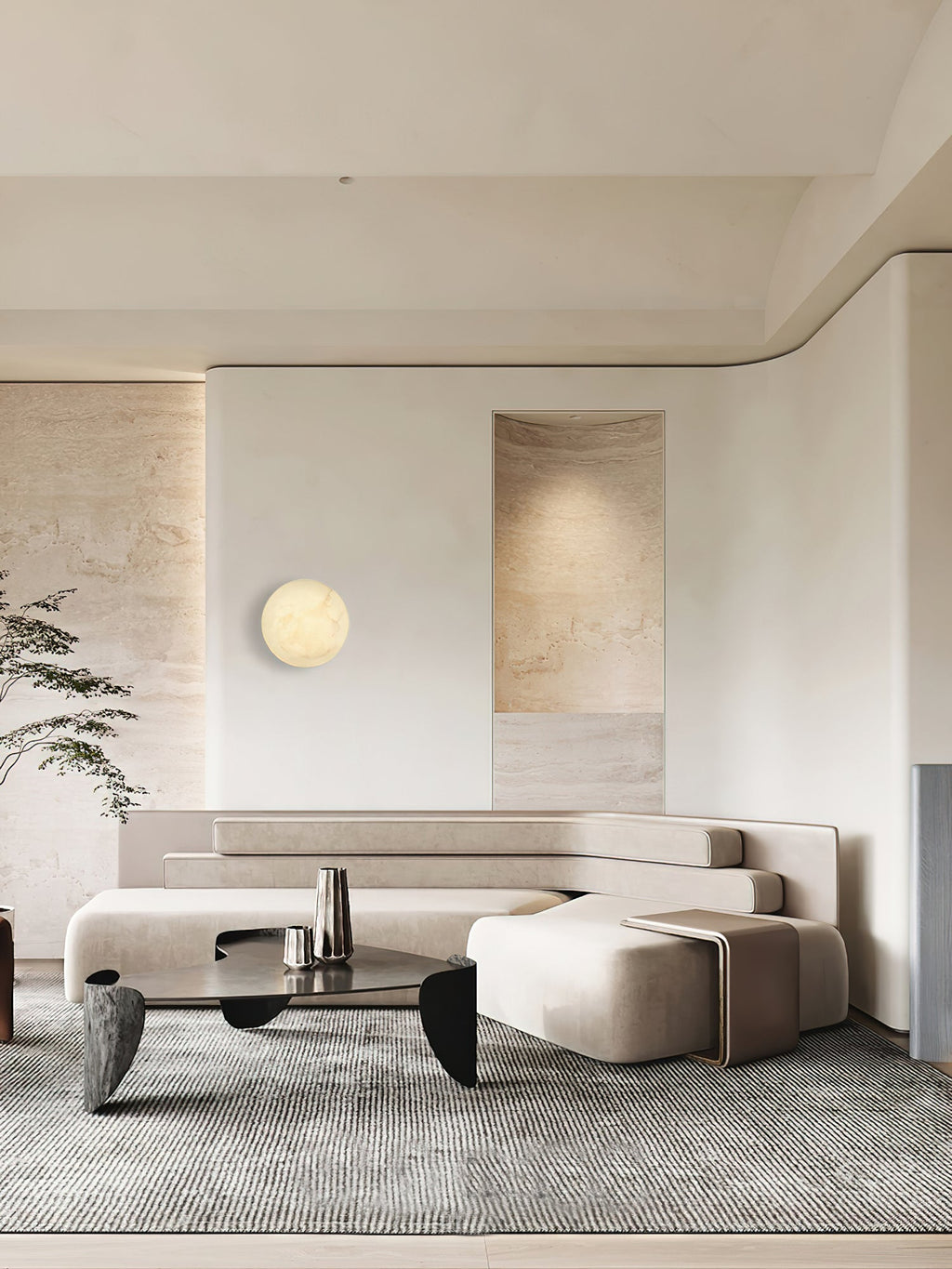 Clérachic Alabaster Wall Sconce on a pale panel in an open living room, framed by travertine walls and a low sofa.