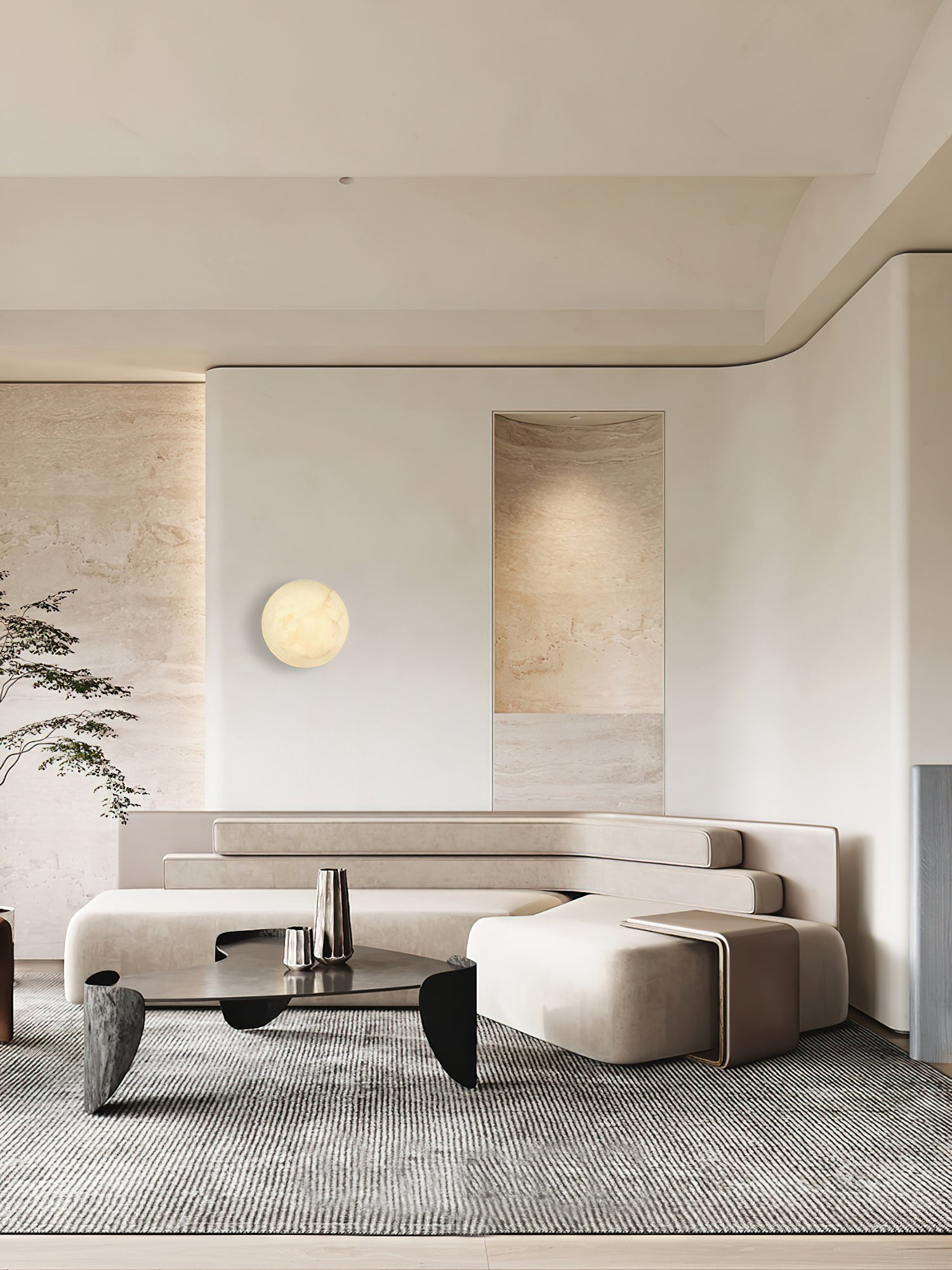 Clérachic Alabaster Wall Sconce on a pale panel in an open living room, framed by travertine walls and a low sofa.