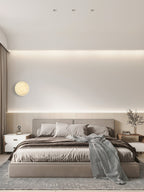 Clérachic Alabaster Wall Sconce on a bedroom wall by the curtain, its warm disc reading against cove-lit plaster.