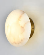 Angled close view of the Clérachic Alabaster Wall Sconce, brass backplate and fixing screw behind the lit stone.