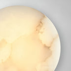 Close crop of the Clérachic Alabaster Wall Sconce, warm light picking out the grey veining near the rim.