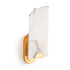 The Clérachic Alabaster Wall Sconce lit on a plain studio wall, warm light washing up through the veined stone slab.