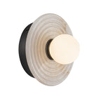 The Clérachic alabaster wall sconce in black, where the ribbed stone disc overlaps a matt black back plate beside a white opal globe.