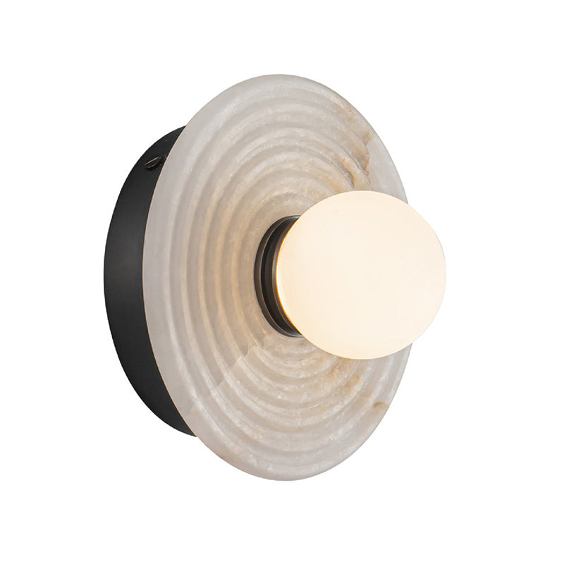 Black-finish Clérachic alabaster sconce seen from the side, the concentric ribs catching light across the stone face.