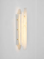 Side view of the lit Clérachic alabaster sconce, showing its stepped panels and a slim back plate with three brass-coloured screws.